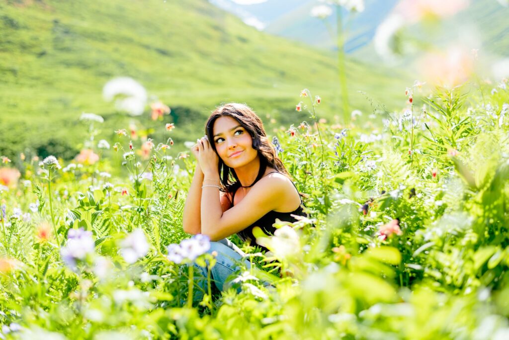 Girl sitting in flower field at Hatcher Pass